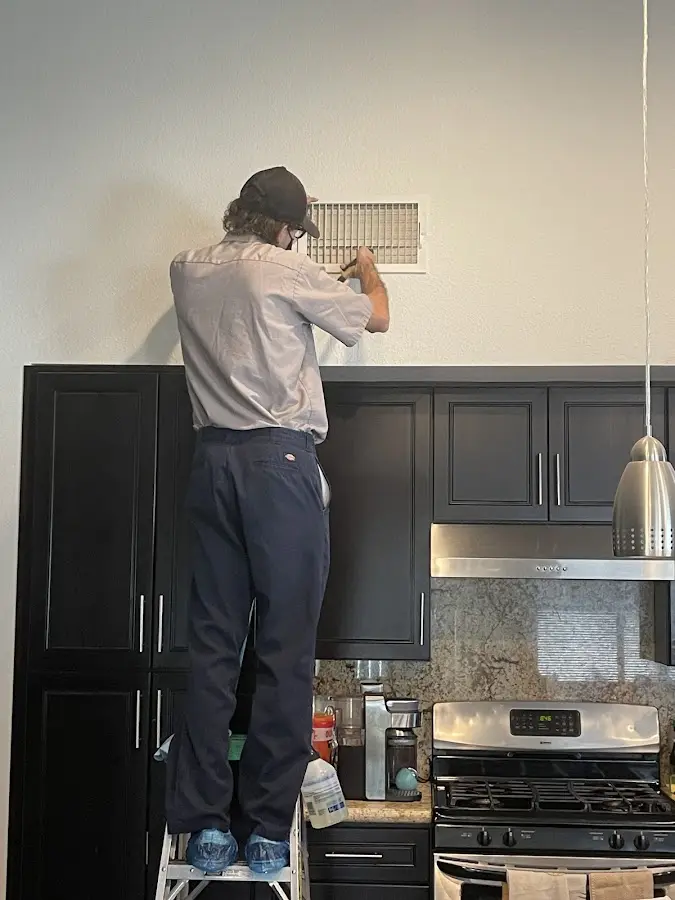 Technician inspecting an air vent during HVAC service in Monrovia